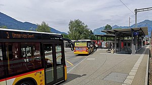 Buses parked next to side platform with shelter