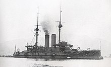 Large warship with smoke rising from the smokestack