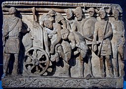 Menelaus and Meriones lifting Patroclus’ corpse on a cart while Odysseus looks on, alabaster, Volterra.