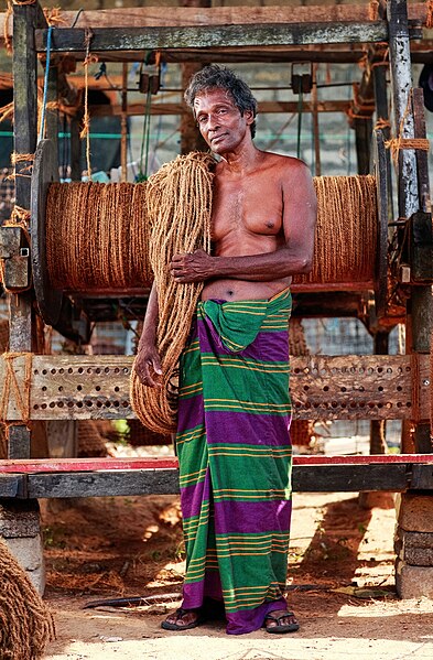 圖為手持椰棕繩的斯里蘭卡工人，這些椰棕繩是用舊設備以傳統方法製造的。