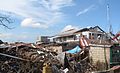 塔克洛班的废墟中，一辆车被卡在严重损毁房屋的瓦砾堆。