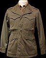 An olive drab M-1943 field jacket, worn by US soldiers during World War II and the Korean War.