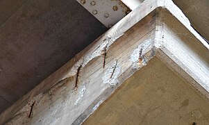 Rusting rebar has expanded and spalled concrete off the surface of this reinforced concrete support