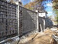 Concrete fence construction using aluminum forms to impart an ashlar stone impression in the finished product