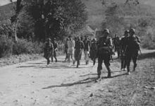 Soldiers escorting civilians with bound hands