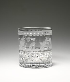 clear cup with engravings that include a dog