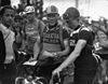 Three male cyclists standing in a row