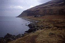 Fairy Dell mouth A lonely house sits on the raised beach at the end of Fairy Dell. Behind, the hillside seems to be tumbling into the sea.