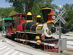 The train engine crossing a path in the zoo