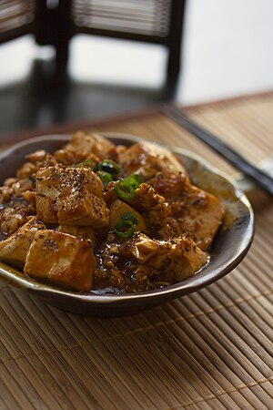 圖為麻婆豆腐，是中国四大菜系中川菜的代表菜品之一，由豆腐、肉碎、豆瓣、花椒、辣椒等烹制而成，凸显了川菜“麻辣”的特点。