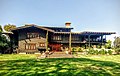 Photograph of the David B. Gamble House across its front lawn. It is a large house with wooden siding and trim presenting a very rustic feel.