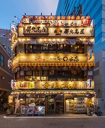 日本东京千代田区有乐町一家3层楼餐厅华灯初上时分的照明立面。
