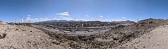 A panoramic view from Sun Bowl Drive at the University of Texas at El Paso, toward the nearby residential neighborhood of Ciudad Juárez, Chihuahua, Mexico, about 350 m away. This pass full of transportation arteries is the "Paso del Norte" after which El Paso is named, the route of the Camino Real de Tierra Adentro (royal road of the interior land) from Mexico to Santa Fe. In this narrow valley are the Interstate 10 freeway, the under-construction (in August 2018) Border West Expressway, the Union Pacific and BNSF railroads, US Highway 85 (Paisano Drive, CanAm Highway), a border fence, the American Canal, and the Rio Grande. The new expressway will mostly occupy space above the railroad tracks.