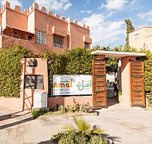 A banner with the center's logo hanging next to 2 large wooden doors that open to the restaurant's courtyard
