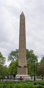 An Egyptian obelisk, standing in a park