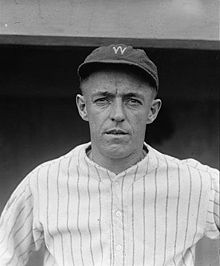 A man wearing a pinstriped baseball jersey and a cap with the letter "W" written on the front