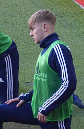 Young man in sports kit stretching