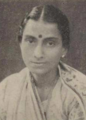 A young South Asian woman wearing a light-colored sari