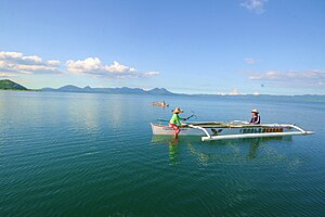 Two people on an outrigger boat