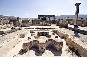 View across a ruined bath complex showing the basins and water features