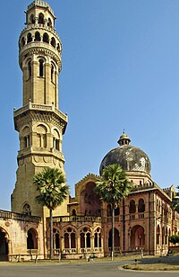 Old red building and tower, with palm trees in front