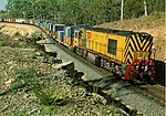 A Tasmanian Railways ZA Class locomotive leads a container train on the Bell Bay line in 1978