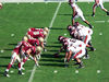 Two college football teams lined up vertically in the image facing each other. The offense with the ball is on the right.