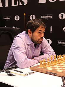 Nakamura looking over a chess board.