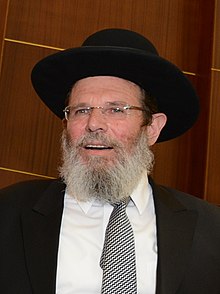 Rabbi Kalman Bar speaking at a podium