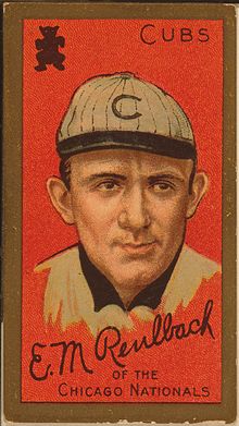 Baseball card showing a head shot of a man facing forward wearing a white hat with a "C" on it. The card says "Cubs" in the upper right corner and says "Ed Reulbach of the Chicago Nationals" on the bottom.
