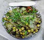Alu kabli, a Bengali alu chat made with sliced boiled potatoes, chickpeas, tomatoes, cucumbers, tamarind sauce, Bengali spices, chopped chillies and garnished with coriander leaves.