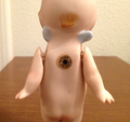 Back of bisque Kewpie, c. 1912: All official Kewpies have signature blue wings on the back of their necks.