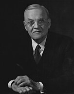 A man wearing transparent tea shades and a suit