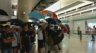 一群市民利用雨伞作保护，当时民主党立法会议员林卓廷亦在场