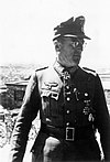 A man wearing a military uniform with an Iron Cross displayed at the front of his uniform collar.
