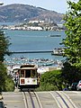 The number 19 car a hill with Alcatraz Island visible in the background