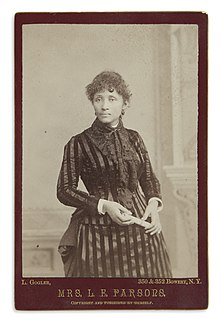 Three quarter length photograph of standing woman in black striped dress