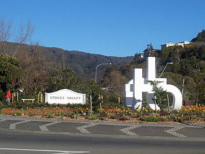 The entrance to Stokes Valley, with the large sculpture Mating Worms by Stokes Valley resident Guy Ngan in the foreground. To the right side are houses in Holborn, which is part of Stokes Valley. In the distance are bush-clad hills at the top end of the valley.