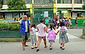 A tanod helping students cross the road at an elementary school in Santa Lucia, Dasmariñas, Cavite