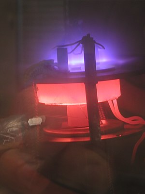 DC plasma (violet) enhances the growth of carbon nanotubes in this laboratory-scale PECVD apparatus.