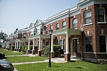 A long 19th century brick building with a white cornice