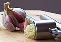 Garlic being crushed using a garlic press