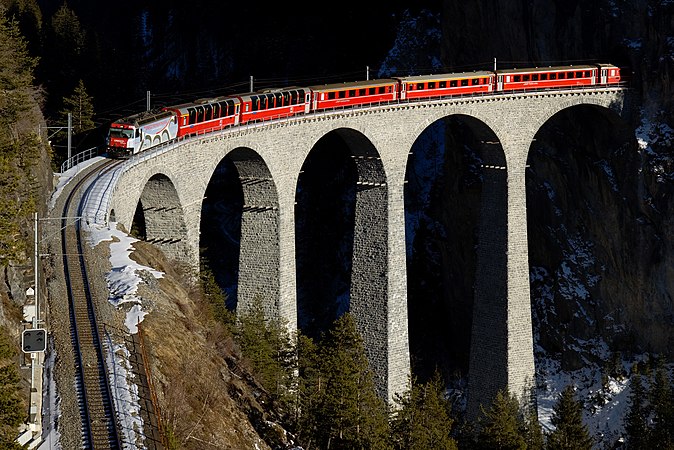 圖為行駛在朗德瓦薩橋上的由Ge 4/4 III型機車（英語：Rhaetian Railway Ge 4/4 III）牽引的區域快車（英語：RegioExpress），正由聖莫里茨開往庫爾。機車頭側面是關於聯合國教科文組織認定的世界遺產——阿爾布拉線和貝爾尼納線的廣告。廣告中標誌性的高架橋與機車正通過的朗德瓦薩橋極為相似。另外注意到前兩節車廂的全景車窗。這種全景車廂的設計多見於貝爾尼納快車；但在冬天，因為貝爾尼納線的車次較少，全景車廂會被調到其他線路上使用。