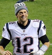 Tom Brady in a winter hat and New England Patriots jersey.