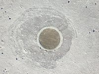 a brass circle flush to a grey stone background.