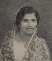 A South Asian woman with dark wavy hair, head covered by a light patterned dupatta