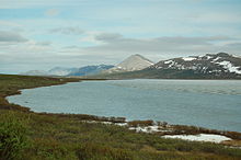 Photograph of the lake with mountains in the background