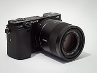 Sony Alpha ILCE-6000 APS-C-frame camera (mirrorless interchangeable-lens camera) with Zeiss lens Sonnar T* FE 1,8/55 ZA attached.