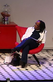 Suely Carneiro, sitting on a red armchair, at the Festival Latinidades, 2016
