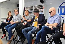 The panel seated in director's chairs